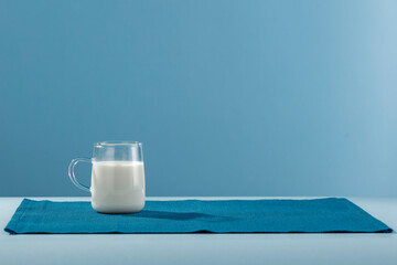 Fresh milk for breakfast in the sunshine on a blue background 