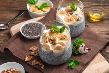 Chia seed pudding with cream, banana, nuts and honey. Natural healthy dessert. Side view, horizontal.