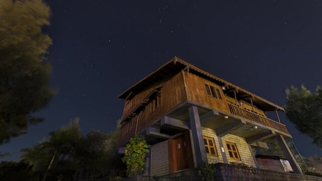 A lone farm house in Forest and Time Lapse of stars moving on a clear night sky, Gujarat, India