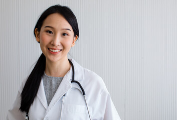 Asian woman doctor long black hair smiling look at camera wearing white uniform with stethoscope on...