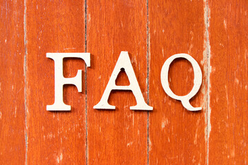 Alphabet letter in word FAQ (Abbreviation of Frequently Asked Questions) on old red color wood...