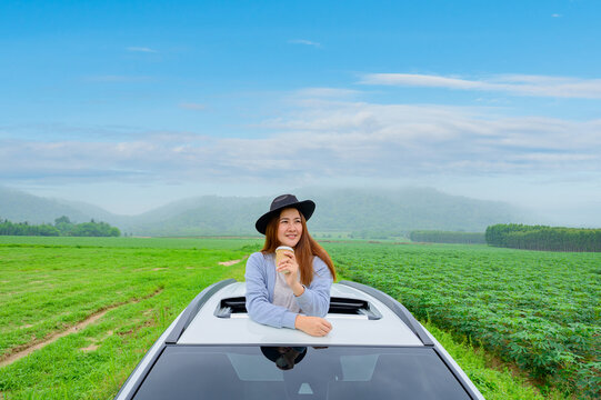 Asian Woman Standing Out Of Car Sunroof. Relaxing And Freedom With Spring Time. Young Tourist Travel Alone In Thailand On Summer Holiday.