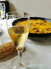 Valencian paella cooking with champagne on log fire in local Spainish village