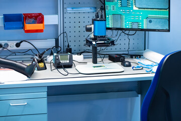 Workplace of a radio-electronics engineer. Soldering iron, extractor hood and electronic microscope...