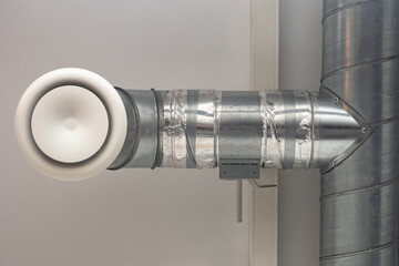 A fragment of ventilation in an industrial room. Indoor air purification system. Metal ventilation pipe. Laying of engineering networks. Ventilation pipes. Air conditioning of buildings.