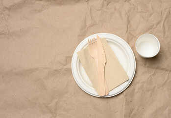 disposable round white paper plate and cup on brown paper background