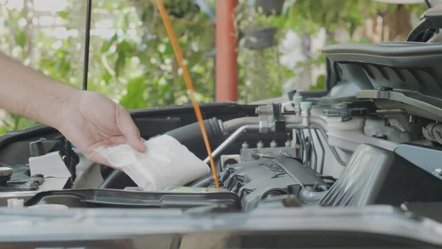 Closeup of man check engine oil level of his car at home by myself. Maintain, check prepare for the trip