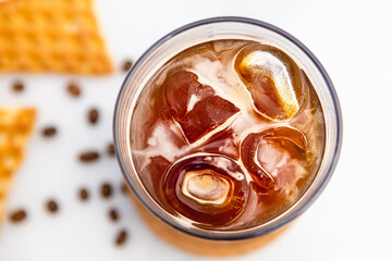 A cup of Iced Americano Coffee with ice cubes placed on a marble table in a coffee shop. Top view...
