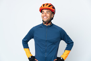 Young cyclist Brazilian man isolated on white background posing with arms at hip and smiling - obrazy, fototapety, plakaty
