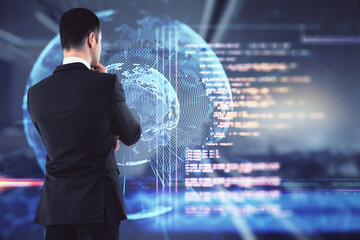 Data base and coding concept with businessman back looking at digital screen with Earth planet layout and blurry coding.