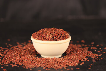 flex seeds in a white bowl with the black background,high fibre flex seed in bowl,Linum usitatissimum,Also known as Linseed