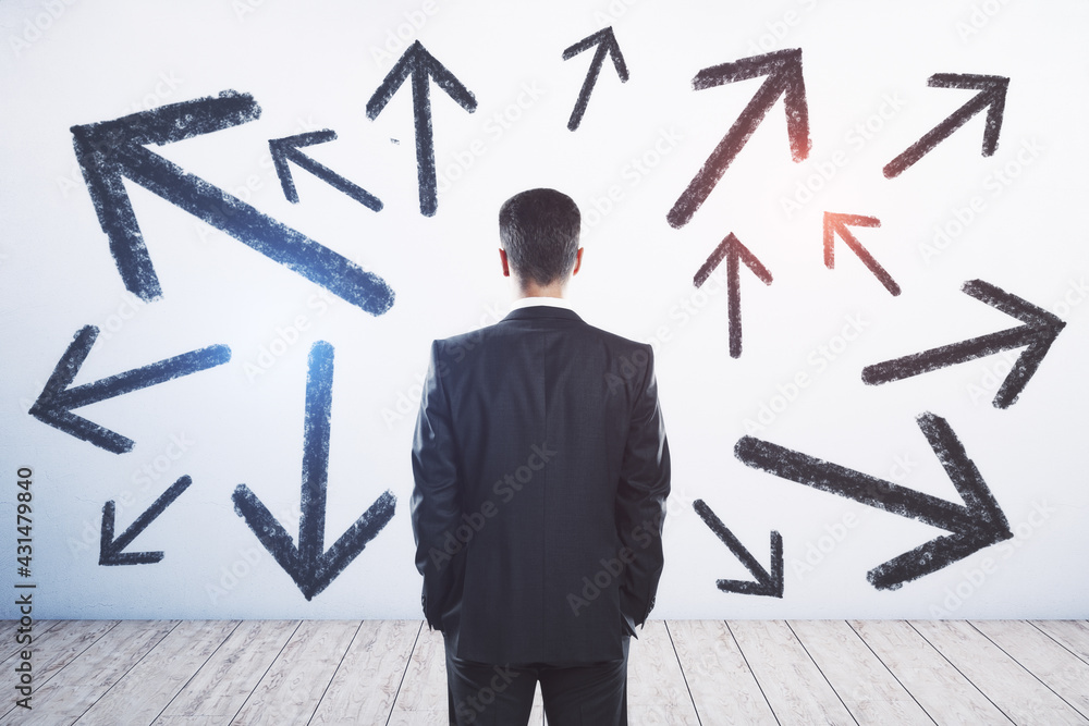 Poster Businessman standing puzzled in front of a wall with multiple black arrows pointed in different directions. Decision making and career path concept