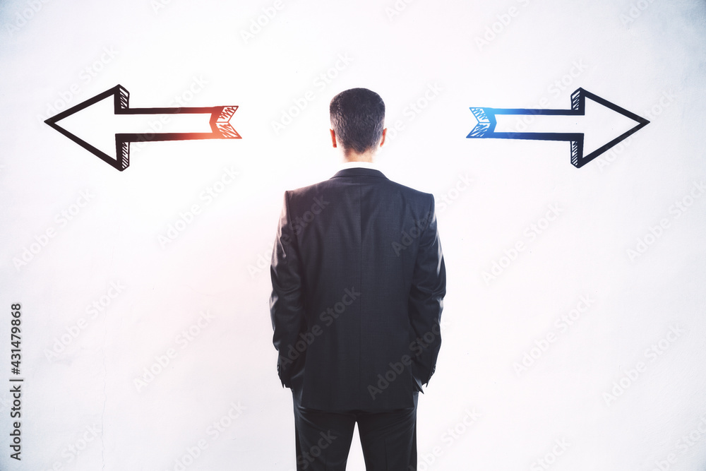 Aufkleber businessman standing puzzled in front of a wall with two black silhouette arrows pointed in opposite