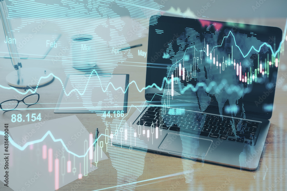 Poster world map and trading charts with a laptop on the desk in the background, global trade and internet 