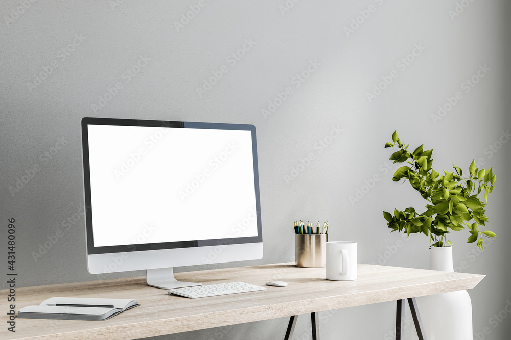 Poster blank white computer monitor on light wooden table with tea cup and notebook on grey wall background