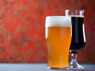 Two glasses of craft beer on a red background, copy space
