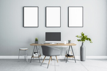 Blank white posters in black picture frame on light wall over stylish work place at home with monitor on wooden table, grey chair and vase on marble floor. 3D rendering, mock up