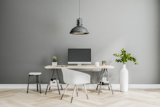 Stylish classic work place at home with modern computer monitor, white chair and vase on wooden floor at grey wall background