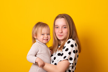 Cute big sister admiring her baby sister. Adorable teen girl holding her new baby girl sister. Kids with large age gap. Big age difference between siblings.