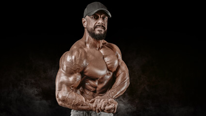 Muscular athlete posing in the studio. Fitness and classic bodybuilding concept.