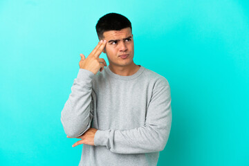 Young handsome man over isolated blue background with problems making suicide gesture