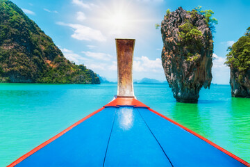 Amazing thai traditional wooden longtail boat view with James Bond island near Koh Panyee village, Phangnga province. One landmark of the most famous tourist attraction in southern Thailand.