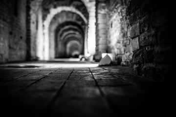 Fototapeta premium Underground passage in the fortress. Close up view from the level of stones on the pavement