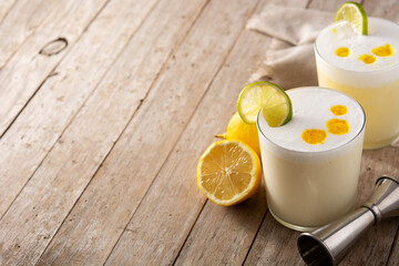 Pisco sour cocktail on wooden table. Traditional peruvian cocktail.Copy space