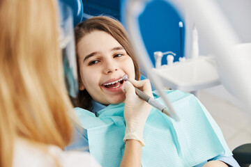 Stomatologist drilling boy teeth with dental drill