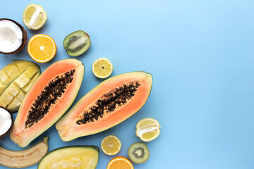 Different fresh tropical cut fruits on a blue background
