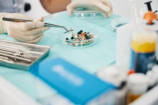 Person picking prophy brush with medical tweezers