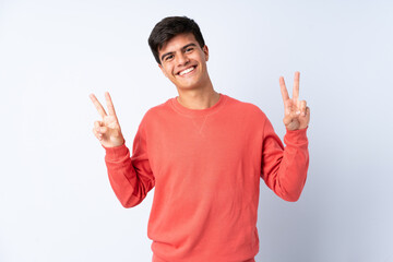 Handsome man over isolated blue background showing victory sign with both hands
