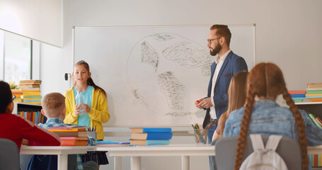 Preteen girl student having presentation in classroom about waste separation.