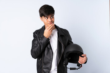 Man with a motorcycle helmet over isolated blue background thinking an idea