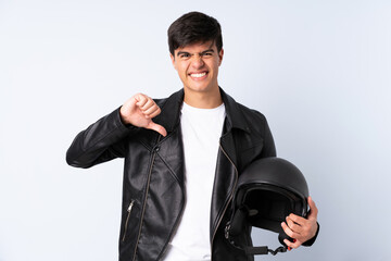 Man with a motorcycle helmet over isolated blue background proud and self-satisfied