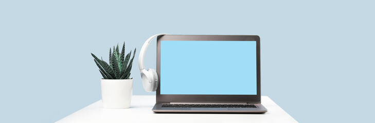 Laptop. Mockup screen and headphones on white desk and plain background banner. Distant learning. working from home, online courses or support minimal concept. Helpdesk or call center headset - obrazy, fototapety, plakaty