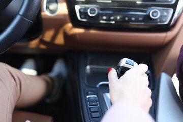 Woman hand holding automatic transmission lever closeup