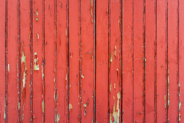 Red weathered wood wall background, peeling paint texture