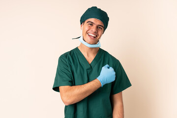 Surgeon man in blue uniform over isolated background celebrating a victory