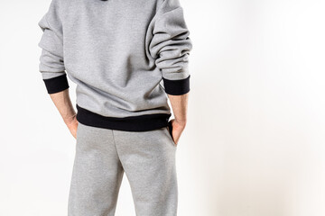 man in a gray tracksuit on a white background, copy space