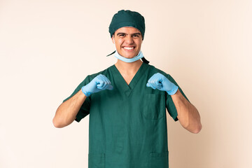 Surgeon man in blue uniform over isolated background proud and self-satisfied