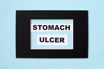 The word ulcer is written on paper in a black frame. Medical concept