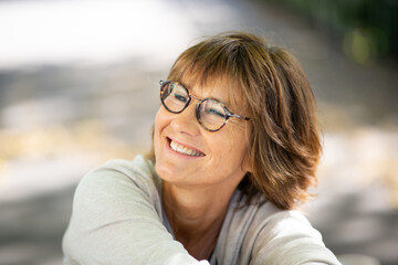 Close up happy woman smiling with eyeglasses and looking away