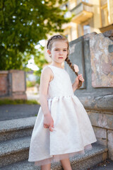 Beautiful young girl in white dress and pretty hairstyle