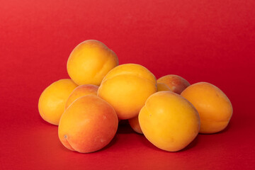 Pile of small, fresh, ripe, juicy, peaches on a colourful background, stock picture.