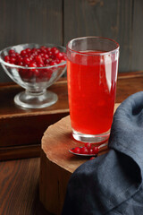 Cranberry cold drink in glass with red berries on wooden rustic background, closeup, winter christmas holiday drinks, healthy healing liquids, natural medicine and naturopathy concept