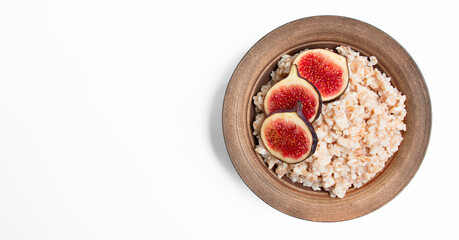 Oatmeal with fresh figs, almonds, cashews and fresh fruits on a white background. Oatmeal with fruits. European breakfast. Banner. Copy space