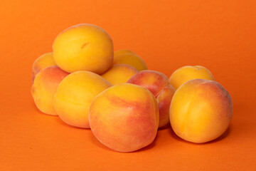 Pile of small, fresh, ripe, juicy, peaches on a colourful background, stock picture.