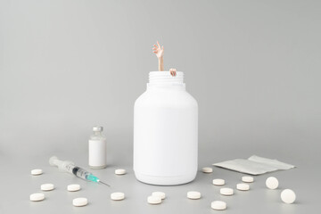 Stop drug addiction and rehabilitation concept. Drug addict hands try to coming out of the pills...