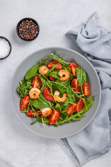 Salad of shrimp prawn and fresh vegetable, leaves of arugula, lettuce.